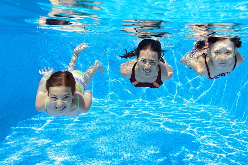 Family smiling underwater