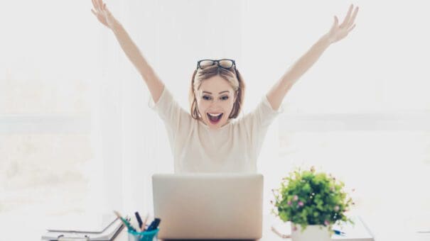 Happy excited successful businesswoman triumphing with laptop