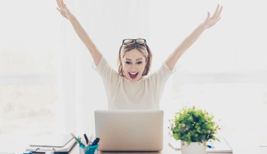 Happy excited successful businesswoman triumphing with laptop