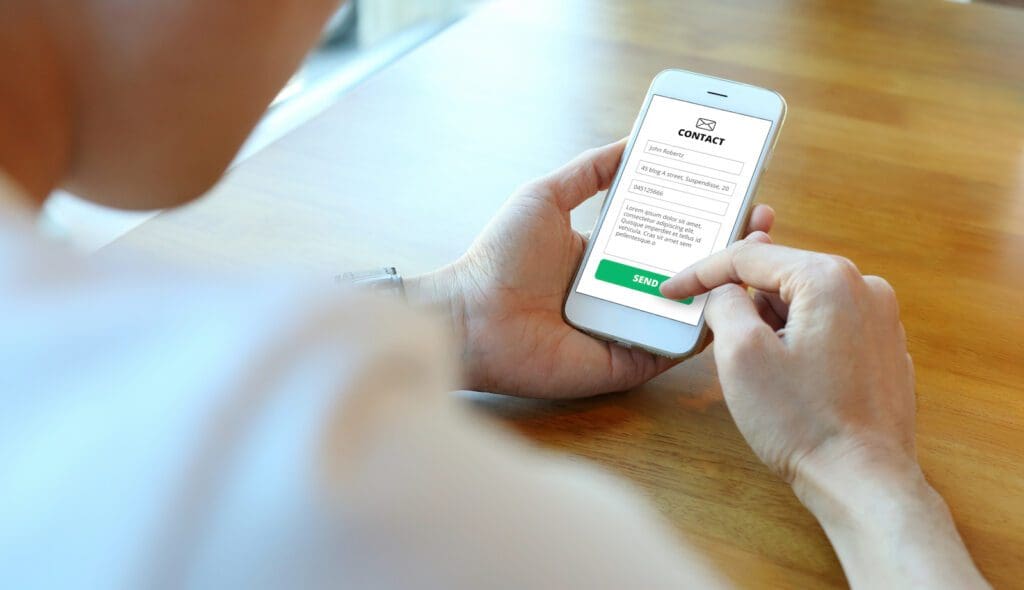 Man holding smartphone with use contact form on website Person submitting form