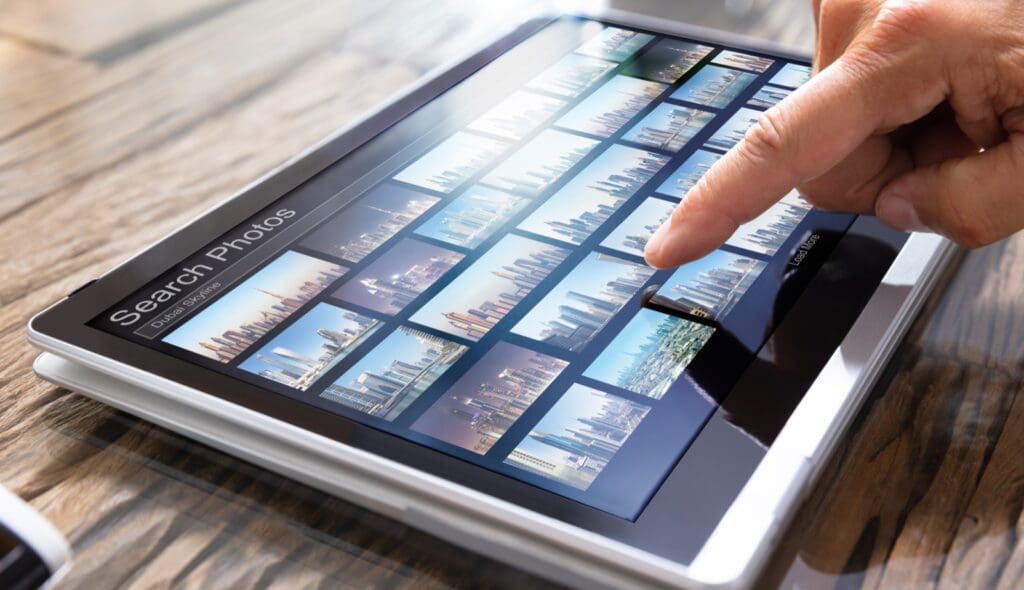 Editor Searching Photos On Tablet Searching for stock photo