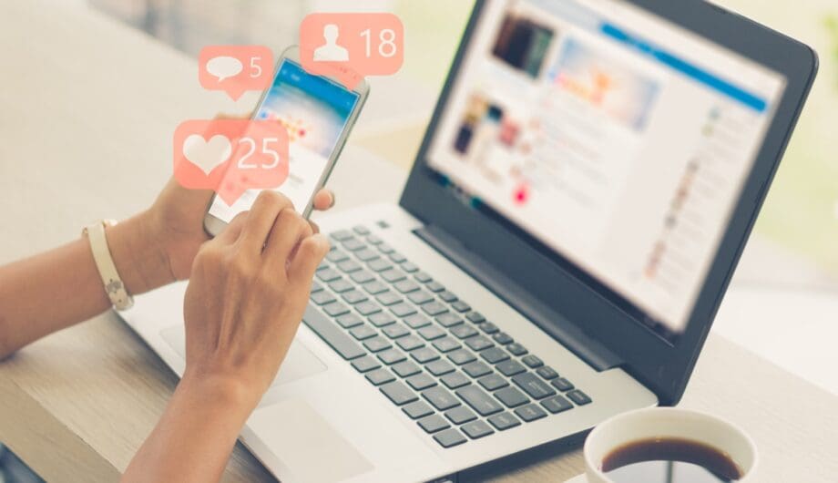 using smart phone,Social media concept Person using social media on phone and laptop: Tips to use social media to promote business