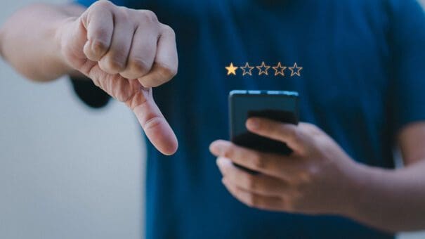Person leaving a bad Google review with a thumbs down. Person leaving a bad Google review with a thumbs down.