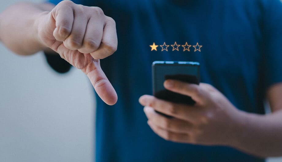 Person leaving a bad Google review with a thumbs down. Person leaving a bad Google review with a thumbs down.