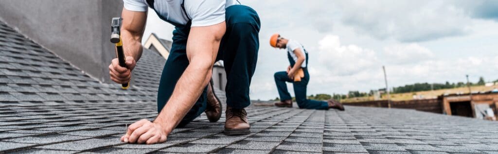 A roofer nailing a shingle to represent roofing website design