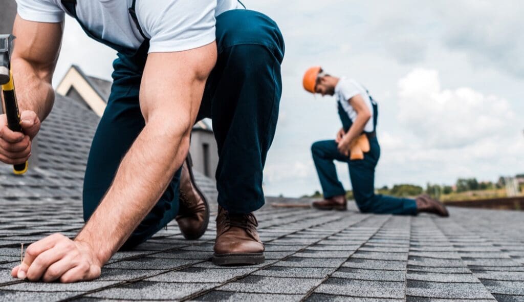 A roofer nailing a shingle A roofer nailing a shingle to represent roofing website design
