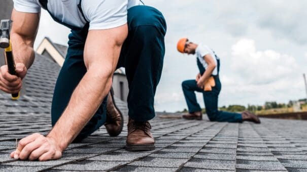 A roofer nailing a shingle to represent roofing website design