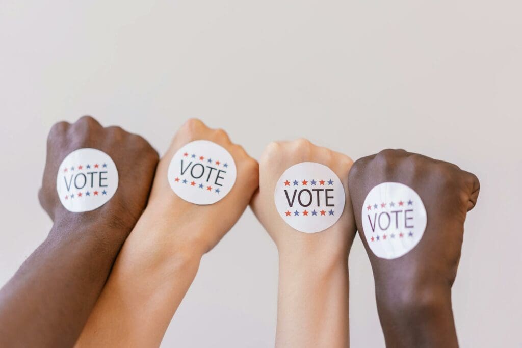 Vote Stickers on the back of voters hands representing the impact of having optimized forms for political websites.