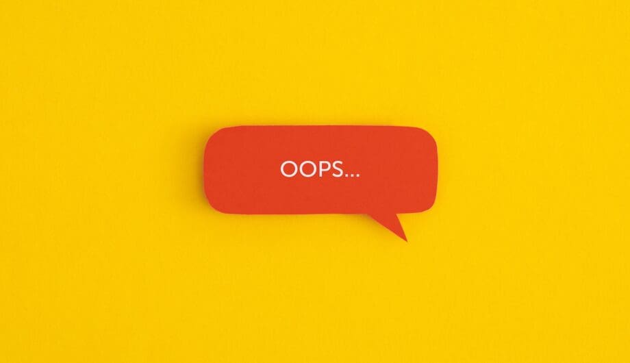 Paper speech bubble with the word "OOPS" on a yellow background. Top view with copy space. Flat lay. Paper speech bubble with the word "OOPS" on a yellow background