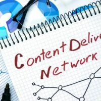 Notepad with words Cdn  Content Delivery Network on a wooden background