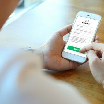 Man holding smartphone with use contact form on website Person submitting form
