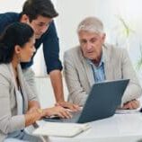 A man working on digital estate planning with two helpers.
