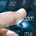 Man selecting a domain extention by pressing an hexagonal button after choosing a name for a webste. Composite image between a hand photography and a 3D background.