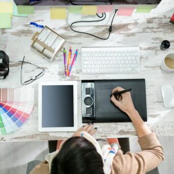 woman designer working on the pen table Logo Design Tips
