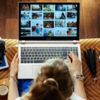 woman looks at image while transferring photos from DSLR camera