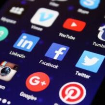 social media icons on a smartphone | Integrating social media into your website