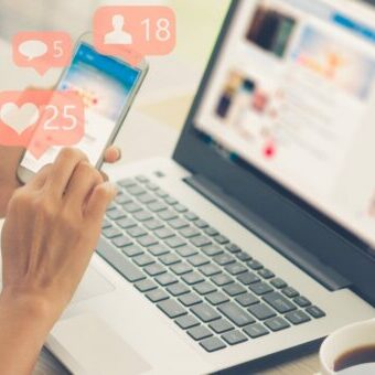 using smart phone,Social media concept Person using social media on phone and laptop: Tips to use social media to promote business