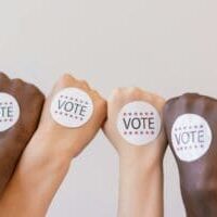 Vote Stickers on the back of voters hands representing the impact of having optimized forms for political websites.